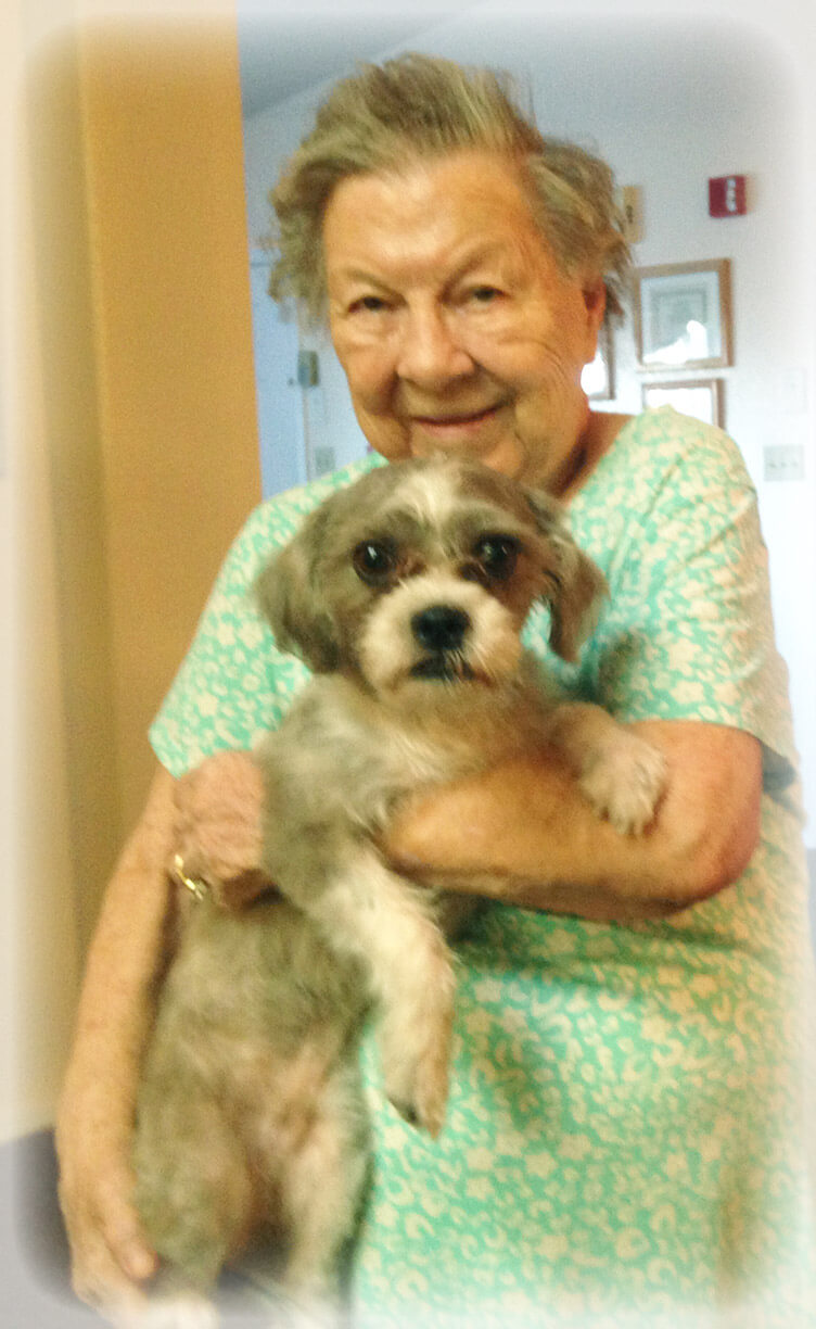 Eden Adult Care Facility resident holding visiting therapy dog